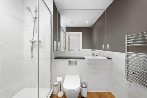 a bathroom with a toilet and a sink and a shower at Modern Serviced 3-bedroom flat in East London in London