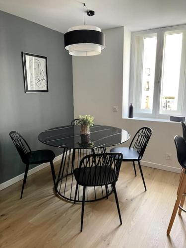 une salle à manger avec une table et des chaises dans une pièce dans l'établissement Escale Concarnoise, Confort et Centre ville à pied, à Concarneau