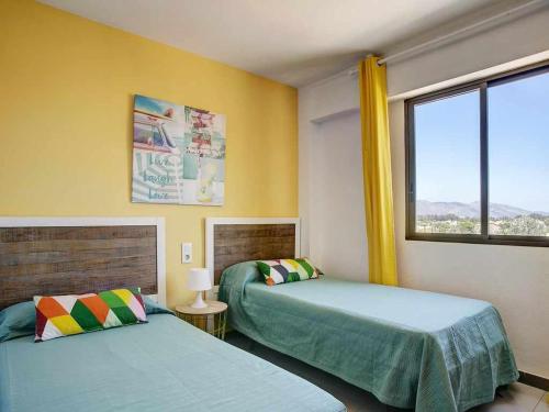 1 dormitorio con 2 camas y ventana en Gardenias de playa gandia, en Puerto de Gandía