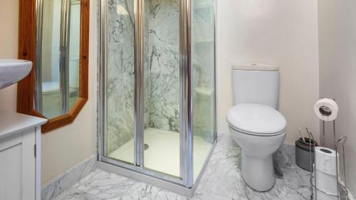 ein Badezimmer mit Toilette und Glasdusche in der Unterkunft Keepers Cottage in Wool