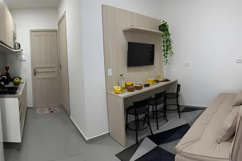 a small kitchen with a bar with stools at Flamingo Pé na Areia in Matinhos