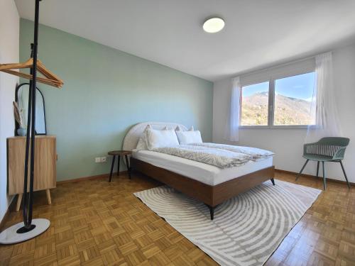 Schlafzimmer mit einem Bett und einem Fenster in der Unterkunft Lily's Charm Apartment in Minusio in Minusio