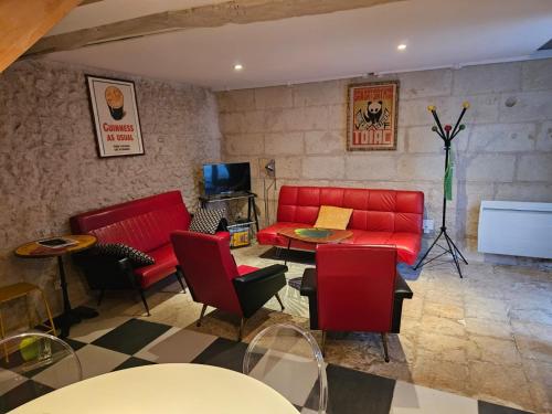 un salon avec un canapé rouge et une table dans l'établissement LA GRANGE DE LA VALLÉE DU CHER, à Chissay-en-Touraine