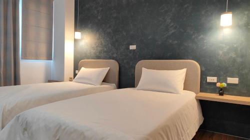 two beds sitting next to each other in a room at Mi Hai B&B in Magong