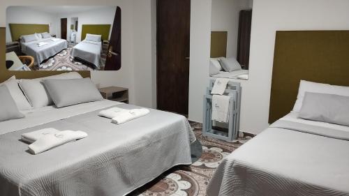 a room with two beds and a mirror at My Place Boutique Hotel in Puerto Iguazú