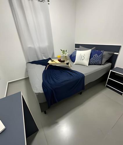 a bedroom with a bed with blue and white pillows at Flamingo Pé na Areia in Matinhos