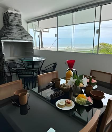 a dining room with a table with food on it at Flamingo Pé na Areia in Matinhos