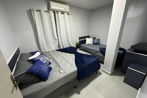 a bedroom with two beds with blue pillows at Flamingo Pé na Areia in Matinhos