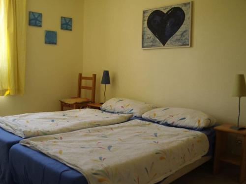 - 2 lits dans une chambre avec un cœur sur le mur dans l'établissement Apartment in Neureichenau, à Portiragnes