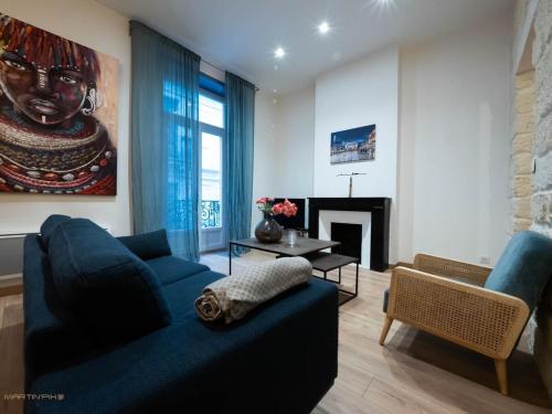 salon z niebieską kanapą i kominkiem w obiekcie Le passage - Centre ville w Montpellier