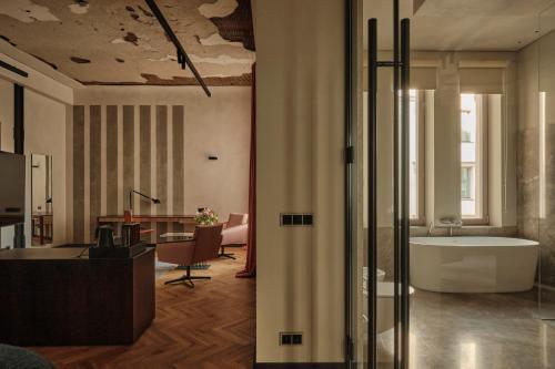 a bathroom with a bath tub and a desk at Grand Hotel in Łódź