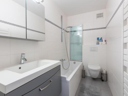 La salle de bains blanche est pourvue d'un lavabo et de toilettes. dans l'établissement Romanza on floor 4, à Middelkerke