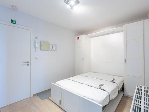 Cette chambre blanche comprend un lit et un placard. dans l'établissement Romanza on floor 4, à Middelkerke