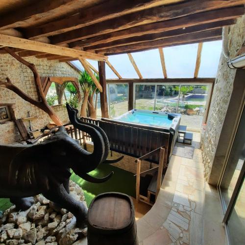 an indoor pool with an elephant statue in a house at gîte des 2 Lions in Murs-et-Gélignieux