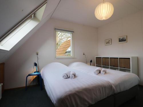 a bedroom with a large white bed with towels on it at Beautiful farmhouse in the middle of nature 