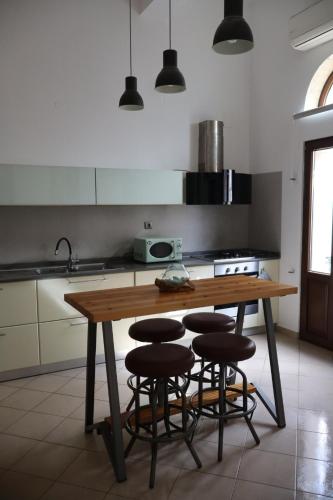 een keuken met een houten tafel en 4 krukken bij FOTEINI RESIDENCE in Kalymnos