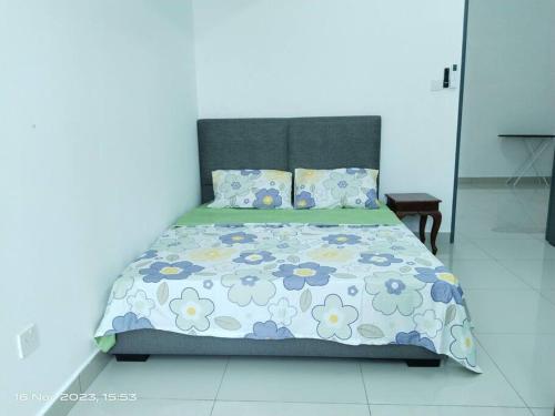 a bed with a floral comforter and pillows at 2 Storey terrace house at masai in Masai