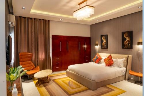 a bedroom with a bed and a desk and a chair at Sujimoto Residences MacDonald in Lagos