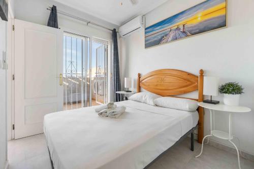 a bedroom with a white bed with a teddy bear on it at HE Paola 2 in Orihuela Costa