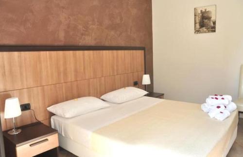 una camera da letto con un grande letto bianco con due cuscini di B&B La Zudrea a Otranto