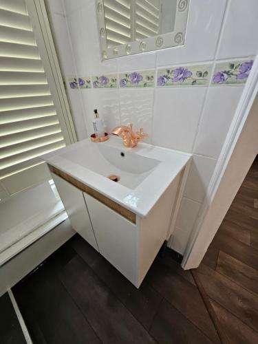 a white bathroom with a sink and a mirror at Studio in central London in London