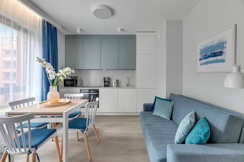 a living room with a blue couch and a table at Scala Apartamenty by Moderna Profit- Łąkowa 60C in Gdańsk