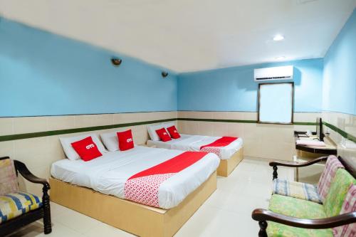 a bedroom with two beds and a desk and chairs at OYO 90208 Milion Inn in Miri