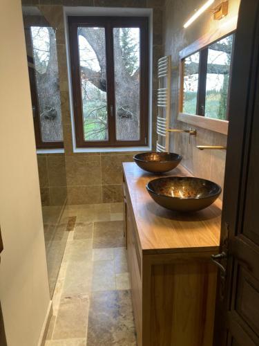 deux lavabos sur un comptoir en bois dans une salle de bain dans l'établissement La belle Maison d'Hôtes d'Aurélie avec SPA professionnel en pleine campagne et proche de tout, à Roquemaure