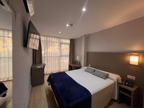 ein Schlafzimmer mit einem Bett und einem großen Fenster in der Unterkunft Hotel Montesol Benidorm in Benidorm