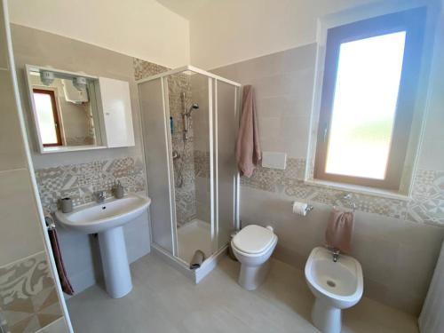 y baño con lavabo, aseo y ducha. en Casa Vacanze Villa Annamaria, en Scanzano Jonico