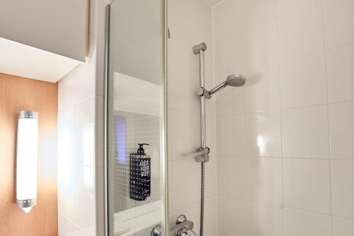 a shower stall with a mirror in a bathroom at ibis Koblenz City in Koblenz