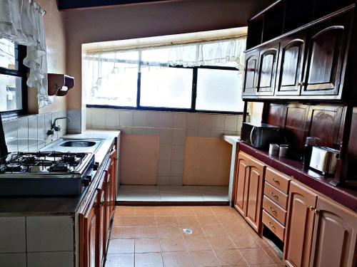 uma cozinha com um fogão, um lavatório e um chuveiro em Hermoso departamento en Ambato em Ambato
