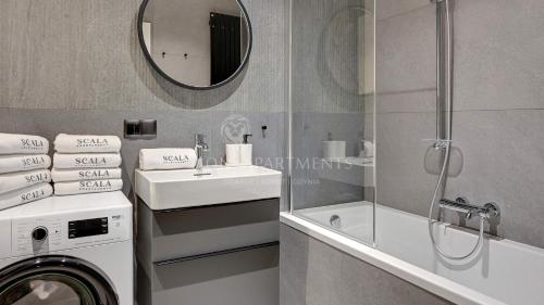 a bathroom with a washing machine and a sink at Lion Apartments - SCALA City Center Mustang&Parking in Gdańsk