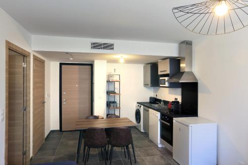 une cuisine avec une table et des chaises dans une pièce dans l'établissement Citadella Calvi T2 cosy et climatisé centre-ville, à Calvi