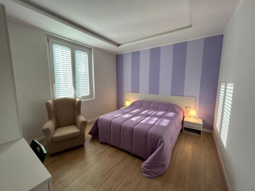 1 dormitorio con 1 cama de color púrpura y 1 silla en Etrusco Viola - Appartamento "Giglio Viola" en Bagno a Ripoli
