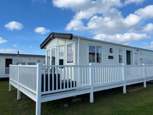 a white mobile home with a white fence at GDs Luxury Caravan Hire Turnberry Holiday Park in Turnberry