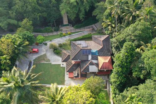 an overhead view of a house with trees and a road at Heaven Palace in Kandy