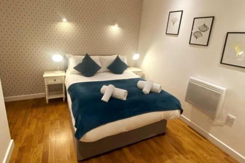 a bedroom with a large bed with blue sheets and pillows at Modern Serviced 1 Bed Apartment - Sleeps 3 Near Heathrow, Thorpe Park, Windsor Castle - Staines TW18 London in Staines upon Thames