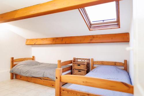 une chambre avec deux lits superposés et une fenêtre dans l'établissement Maison Pavillon St Pierre avec terrasse de 80m², à Fleury