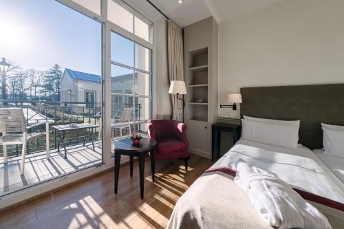 a hotel room with a bed and a large window at Parkhotel Surenburg in Hörstel