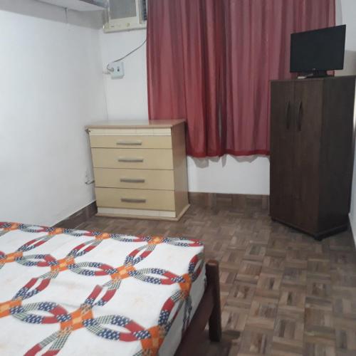 a bedroom with a bed and a dresser and a television at Andrade 2 in Rio de Janeiro