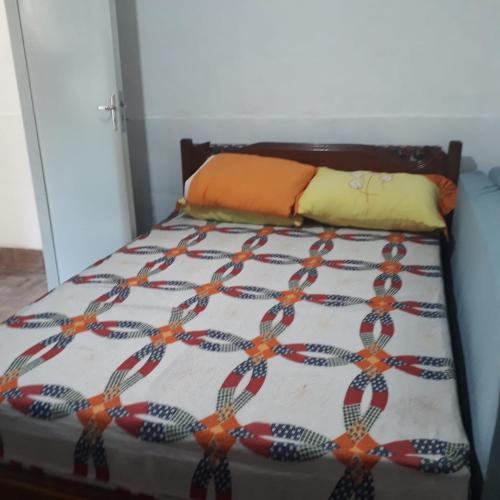 a bed with a comforter with ties on it at Andrade 2 in Rio de Janeiro