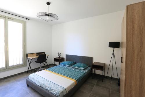 une chambre avec un lit et un bureau dans l'établissement Citadella Calvi T2 cosy et climatisé centre-ville, à Calvi