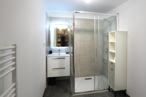 une salle de bain blanche avec un lavabo et une douche dans l'établissement Citadella Calvi T2 cosy et climatisé centre-ville, à Calvi