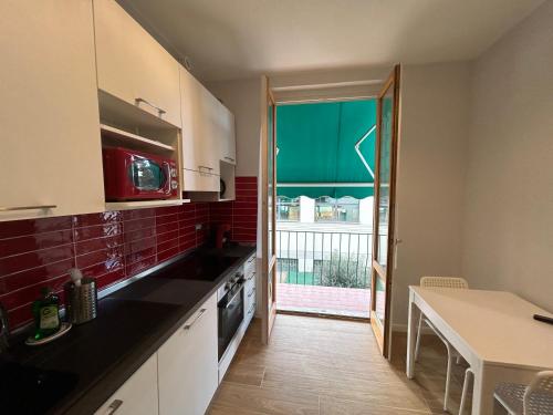 a kitchen with a sink and a door to a balcony at Etrusco Viola - Appartamento "Giglio Viola" in Bagno a Ripoli