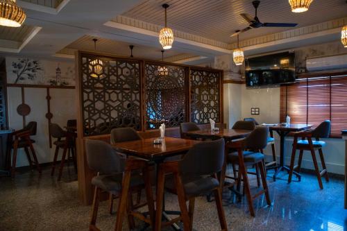 a dining room with tables and chairs and chandeliers at PVR Suites off Bannerghatta Road in Bangalore