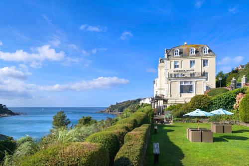 ein Gebäude auf einem Hügel neben dem Meer in der Unterkunft Harbour Hotel Fowey in Fowey