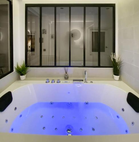 a large blue tub in a bathroom with a window at L'Amanté Spa -Balnéo -Vieux Lyon in Lyon