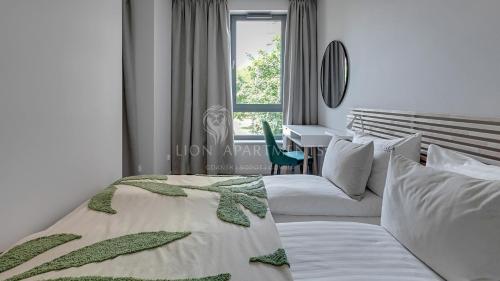 - une chambre avec 2 lits et un bureau dans l'établissement Lion Apartments - SCALA City Center Apartments&Parking H, à Gdańsk