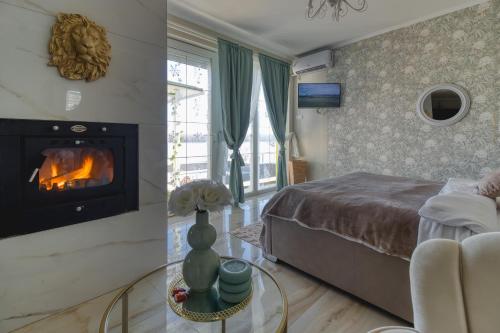 a bedroom with a fireplace and a bed at Bungalow Lux 2 in Novi Banovci